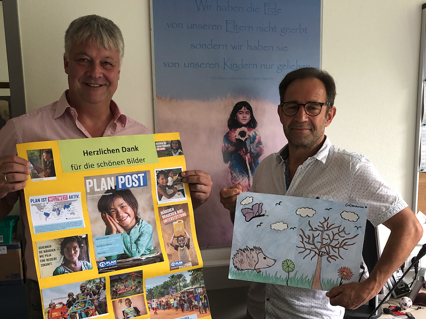 Herr Lorenz (links) und Herrn Ströbele zeigt das Dankeschön Plakat für die Schule und die ausgezeichneten Bilder (Foto: Bärbele Herr)