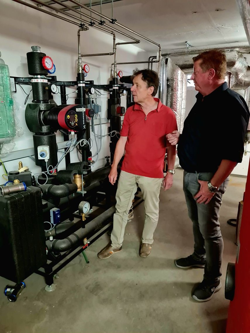 Bild: Planer Elko Vopel und SWG-Projektleiter Steffen Peter (r.) besprechen vor der neuen Fernw&auml;rme&uuml;bergabestation im Keller des Seniorenwohnblocks letzte Details