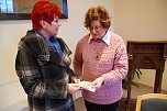 Brigitta Mehwald (links) spendierte der Aktion "Hettstedter Weihnachtsp&auml;ckchen" drei ihrer Bilder mit Hettstedt-Motiven. Sie wurden versteigert und erl&ouml;sten 250 Euro. Die H&auml;lfte davon erhalten bed&uuml;rftige Hettstedter Kinder, die andere H&auml;lfte rundete sie auf 150 Euro auf und spendierte sie f&uuml;r die Sanierung der Arnstedter Kirchenfenster. (Foto: Jochen Miche)