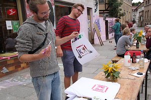 Deniz Adam (links) bringt mit Airbrush das Doppel-K der Kulturkonditorei auf ein Shirt. Paul Sander ist begeistert