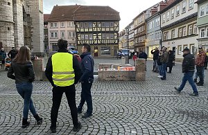 Am Brunnenrand brennen Kerzen als symbolische Friedenslichter