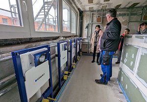 Kitaleiterin Jana Bauer (links) und ihre Mitarbeiterin betrachten die entstehenden Sanit&auml;rr&auml;ume in der Innenstadtkita.
