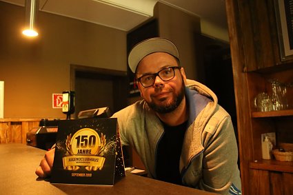 Bild: Hausleiter Christoph Rode mit dem Flyer zur Festwoche