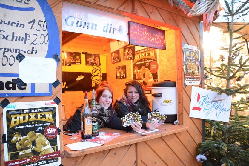 An der Boxer Gl&uuml;hweinbude freuen sich Julia Scholz (links) und Felicitas Heyke auf viele Besucher, die sich bei einem hei&szlig;en Gl&uuml;hwein oder einem fruchtigen Kinderpunsch aufw&auml;rmen wollen. Karten haben die beiden auch im Verkauf - f&uuml;r den Boxabend des NSV gegen den SV Motor Babelsberg am Samstag, 20. Dezember, um 19.30 Uhr in der Ballspielhalle. (Foto: Sandra Arm)