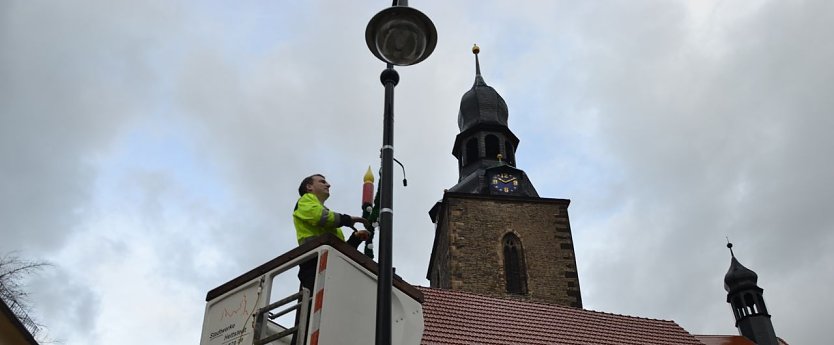 Daniel N&ouml;thlich von den Stadtwerken Hettstedt montiert vom Hubsteiger aus die weihnachtliche Lichterdekoration an Laternen der Innenstadt. (Foto: Jochen Miche)