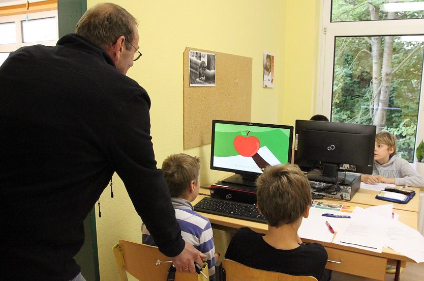 Sch&uuml;lerinnen und Sch&uuml;ler der Klassen 5/6 arbeiten gemeinsam an einem Apfel-Projekt: W&auml;hrend einige &Auml;pfel sch&auml;len und Muffins backen, recherchieren andere im Internet nach sch&ouml;nen Gedichten zur s&uuml;&szlig;en Frucht, die dann abgeschrieben werden und am Ende des Unterrichtstages zum Vortrag kommen (Foto: Sylvia Spehr)