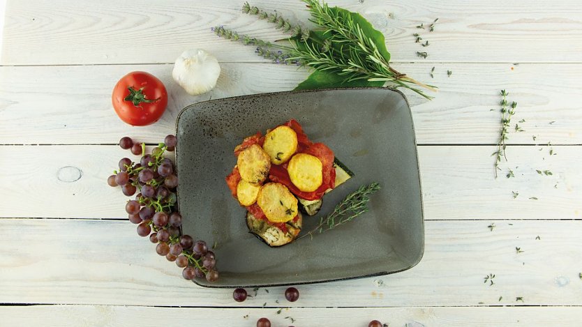 Das mallorquinische Tumbet mit ger&ouml;steten Kartoffeln und Gem&uuml;se bringt einen Hauch Mittelmeer auf den sommerlich gedeckten Tisch (Foto: Kartoffel-Marketing)