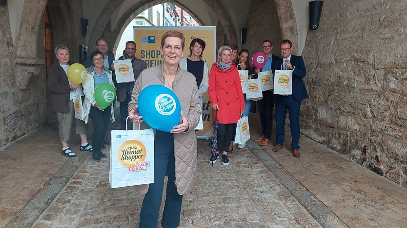 Modegesch&auml;fts-Inhaberin Barabara Endepols (vorn) stellte gemeinsam mit den Einzelh&auml;ndlerinnen Annegret Spallek, Petra Wehrsporn und Silke Ressel, Oberb&uuml;rgermeister Dr. Johannes Bruns, Birte Frerichs vom Stadtmarketing, Jan Riemann vom Verein ZiM, Susanne Sturm und Marcel &Uuml;bensee von der IHK Erfurt sowie Sparkassen-Vorstand Christian Blechschmidt das Angebot zum M&uuml;hlh&auml;user Heimatshoppen 2022 vor. (Foto: Stadtverwaltung M&uuml;hlhausen)