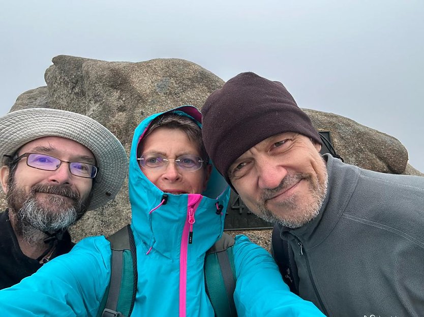 Die H&auml;lfte der Strecke ist fast geschafft: Gipfelselfie nach den ersten zehn Wanderstunden morgens um halb Sechs auf dem Brocken: Dr. Christian Richter, Antje-Otte Hartig, Bodo Schwarzberg (Foto: Antje Otte-Hartig)