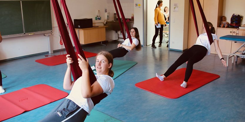 Gem&uuml;tlich abh&auml;ngen ist hier nicht angesagt - die jungen Physiotherapeutinnen m&uuml;ssen lernen, wie man Patienten im H&auml;ngetuch effektiv behandeln kann (Foto: agl)