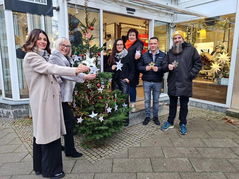 Katja Wohlenberg, Kerstin Esther, Katja Trautmann, Manuela Hebestreit, Maik Diestel und Heiko S&auml;nger (von links) pr&auml;sentieren in der Rautenstra&szlig;e 5 die Wunschsterne, die vor den teilnehmenden Gesch&auml;ften in den B&auml;umen h&auml;ngen.  (Foto: SWG Nordhausen/S. Schedwill)