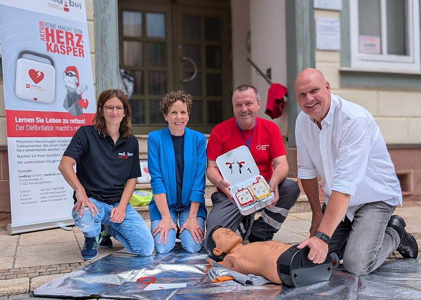 Proben die Reanimation mit Defibrillator in der Fu&szlig;g&auml;ngerzone (v.l.n.r.): Kristin Rothmann, Andrea Westermeyer, Sven Oesterheld und B&uuml;rgermeister Steffen Grimm (Foto: Janine Skara)