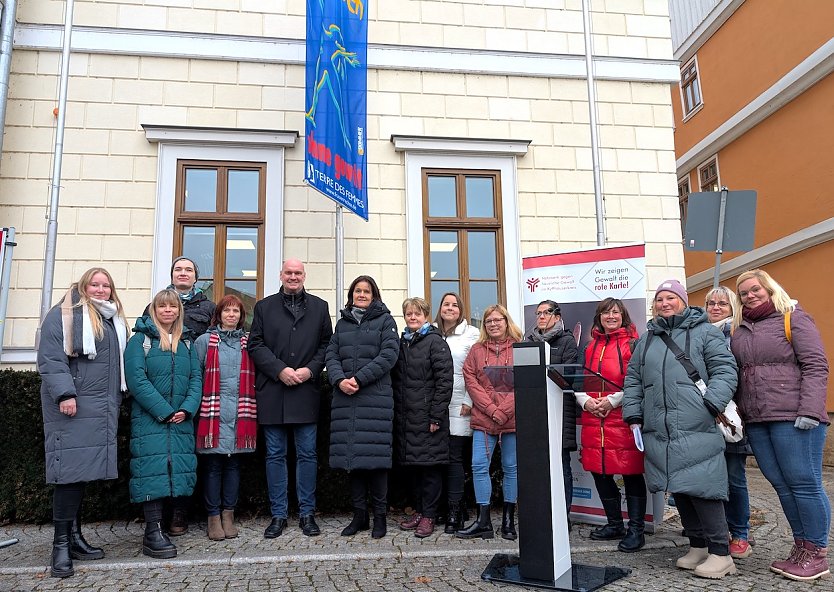 Landr&auml;tin Antje Hochwind-Schneider (6.v.li.), B&uuml;rgermeister Steffen Grimm (5.v.li.) und das Netzwerk gegen h&auml;usliche Gewalt im Kyffh&auml;userkreis hissten die Fahne der Frauenrechtsorganisation Terre de Femme. (Foto: Janine Skara)