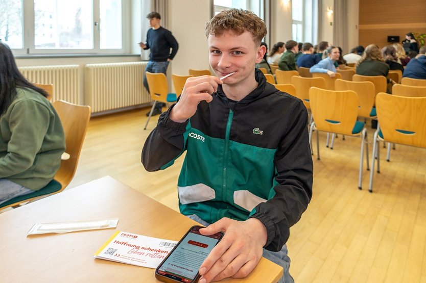 Bild: Ein junger Mann mit einem Testst&auml;bchen im Mund