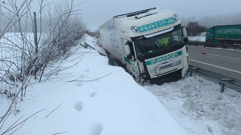 Bild: Ein Lkw liegt auf einer Hangb&ouml;schung im schneebedeckten Stra&szlig;engraben. 