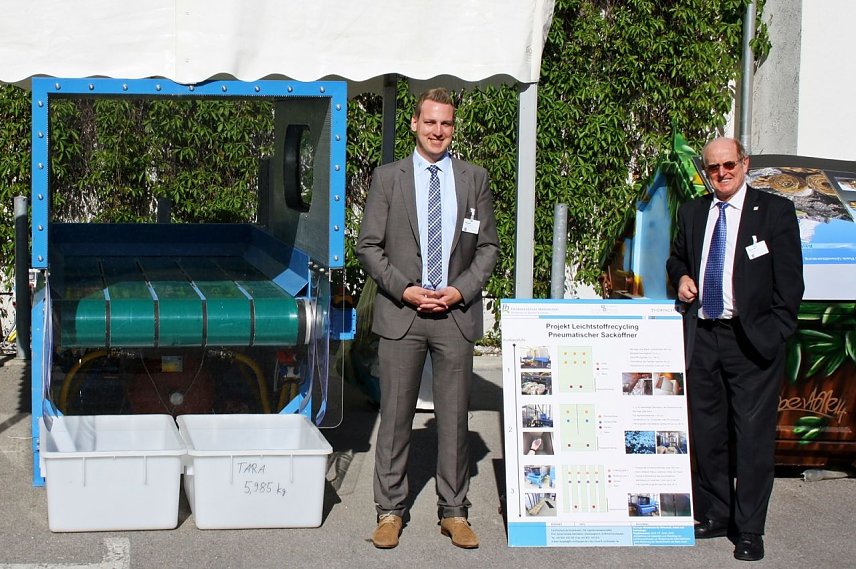 Bild: Dr. J&uuml;rgen Poerschke und M. Eng. Christian Borowski (v.r.) am Messestand auf der IFAT mit pneumatischem Sack&ouml;ffner   