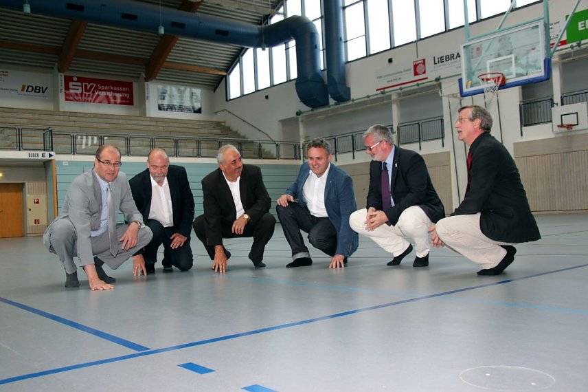 Bild: Nur mit Sportschuhen erlaubt - auch Matthias Jendricke, der Leiter der Schulverwaltung Hans-Georg M&uuml;ller, Schulsportkoordinator Werner H&uuml;tcher, Gunnar Reuter, Leiter des B&uuml;ros des Landrates/Zentrale Dienste, Bildungsdezernent Stefan N&uuml;&szlig;le und Wilhelm K&ouml;nig, der stellvertretende Schulleiter des Herder-Gymnasiums haben den neuen Boden nur auf Socken betreten, als sie sich die Wiedigsburghalle jetzt 