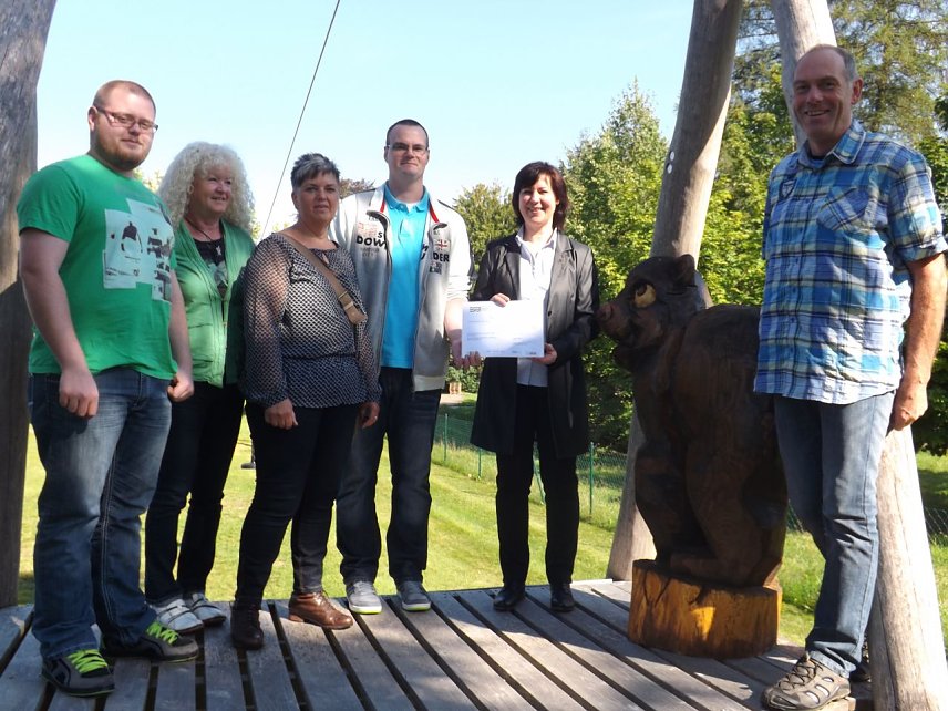 Bild: Gemeinsam mit der Geldspende wurde auch die lebensgro&szlig;e Holzskulptur eines Braunb&auml;ren an das Hospiz &uuml;bergeben.