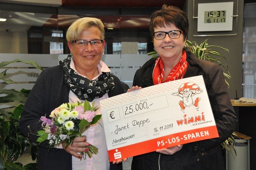 Bild: Kundenberaterin Renate Krause &uuml;berreicht der gl&uuml;cklichen Gewinnerin den symbolischen Scheck