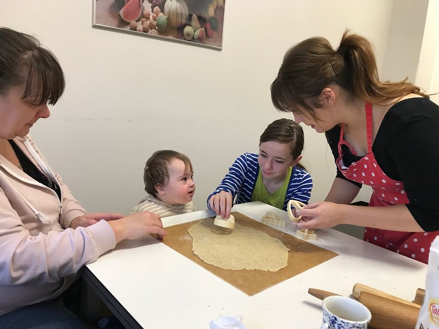 Bild: Der kleine Luca mit Mama und gro&szlig;er Schwester; rechts im Bild: Heilp&auml;dagogin Anna Kniep