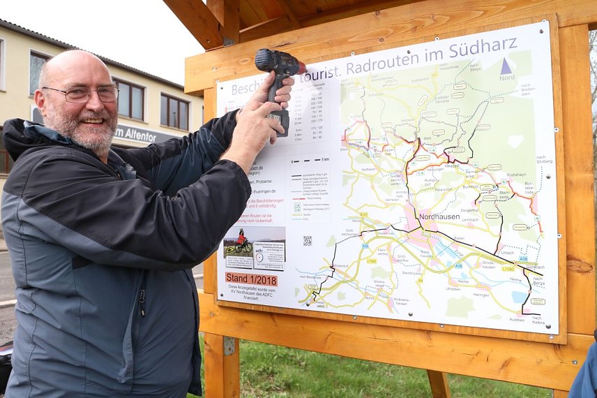 Bild: Der Vorsitzende des Nordh&auml;user ADFC Kar-Heinz Gr&ouml;pler bringt die letzte Schraube an der neuen Tafel an