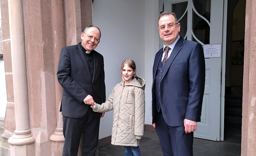 Bild: Bischof Ulrich Neymeyr (l.) und Direktor Heinz-Peter Kaes (r.), Schulleiter des Gymnasiums Bergschule St. Elisabeth, begr&uuml;&szlig;en die Sch&uuml;lerin Lena Schwarz (Mitte) in der Anmeldewoche f&uuml;r die neue Regelschule