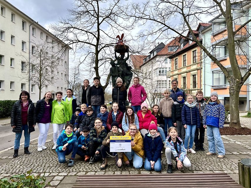 Bild: Erster geschm&uuml;ckter Brunnen f&uuml;r Brunnenfest 2023 � Oberb&uuml;rgermeister Kai Buchmann mit Sch&uuml;lern der Grundschule K&auml;the-Kollwitz und der Zahnarztpraxis Wurzeleck