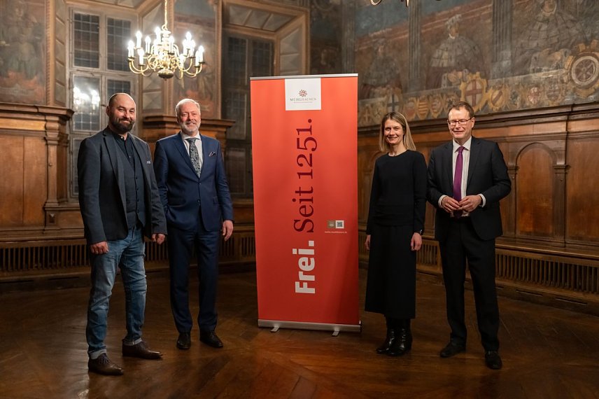 Bild: Christian K&uuml;mpel (Stadtmarketing), Stadtarchivar Dr. Helge Wittmann, Ann-Kristin Zabel-Fr&ouml;hlich (Leiterin Fachbereich Wirtschaft und Soziales) und Oberb&uuml;rgermeister Dr. Johannes Bruns stellten die neue Markenstrategie im Historischen M&uuml;hlh&auml;user Rathaus vor (v.l.).