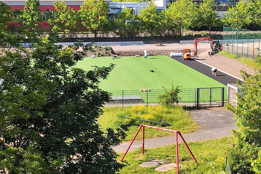 Bild: Verlegung des Kunstrasens vor der Halle