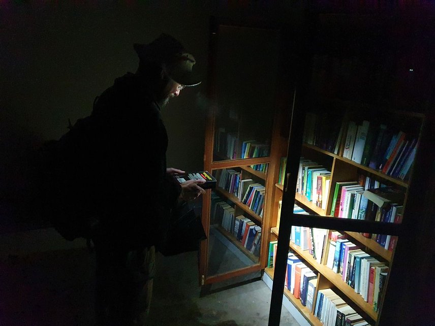 Bild: Hier sind wir nicht in eine fremde Wohnstube eingedrungen: In Morungen gibt es eine exklusive Bushaltestelle mit reich gef&uuml;llten B&uuml;cherschr&auml;nken zur kostenlosen Bedienung. Wanderfreund Christian aus Jena l&auml;sst es sich nicht nehmen, im Schein seiner Taschenlampe ein wenig zu st&ouml;bern und schlie&szlig;lich ein Buchexemplar in seinen Rucksack zu stecken. 
