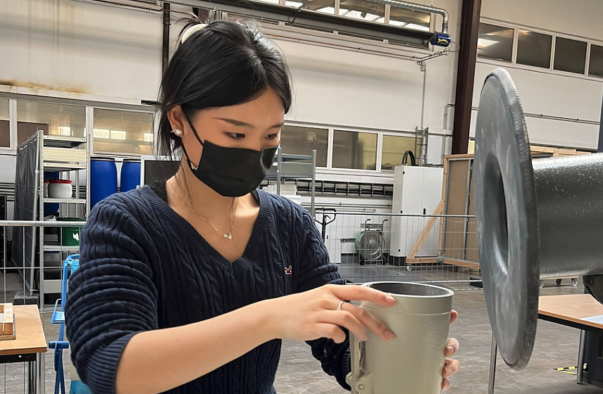 Bild: Yuwei Chang pr&uuml;ft sorgf&auml;ltig ein Bauteil im Labor � eine Verbindung von akademischem Wissen und praktischer Anwendung