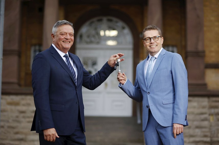 Bild: Frank Lehmann (li.) und Bj&ouml;rn Bosse bei der Staffelstab&uuml;bergabe vor der IHK-Gesch&auml;ftsstelle des Landkreises Mansfeld-S&uuml;dharz in Sangerhausen