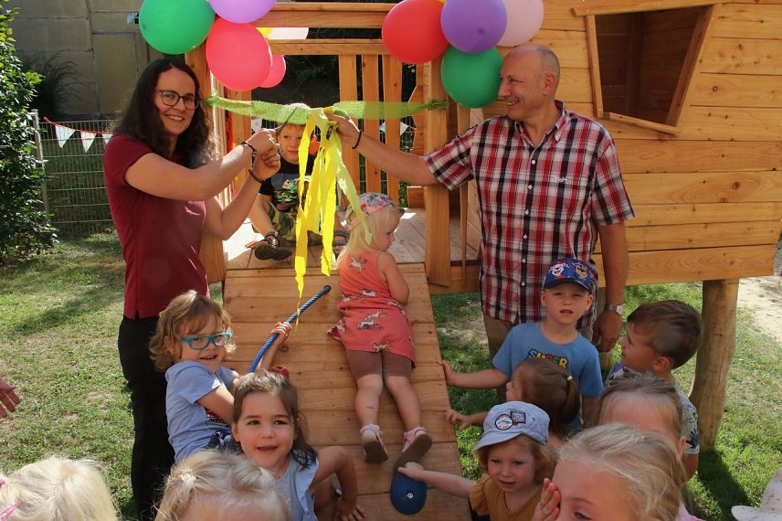 Bild: Maria L&ouml;ther von der "Energiequelle" und Maik G&ouml;llert von "Abo Energy" &uuml;bergaben gemeinsam das neue Spielhaus f&uuml;r den Werther'schen Kindergarten