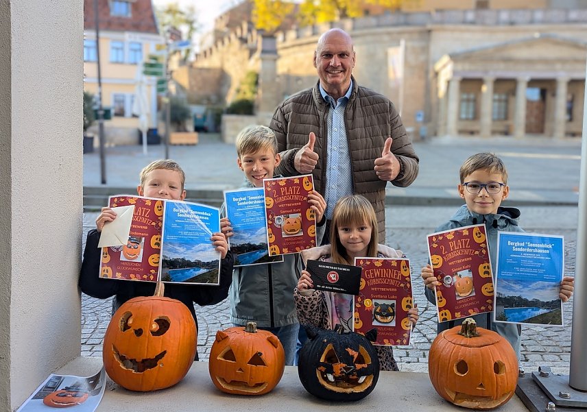 Bild: B&uuml;rgermeister Steffen Grimm (Mitte) mit den gl&uuml;cklichen Gewinnern des diesj&auml;hrigen K&uuml;rbisschnitzwettbewerbes (v.l.n.r.): Emil Bodemann (2. Platz), Samuel Koch (2. Platz), Gewinnerin Svetlana Luks und Simon Kohl (2. Platz). Carl Bodemann gewann den 3. Platz.