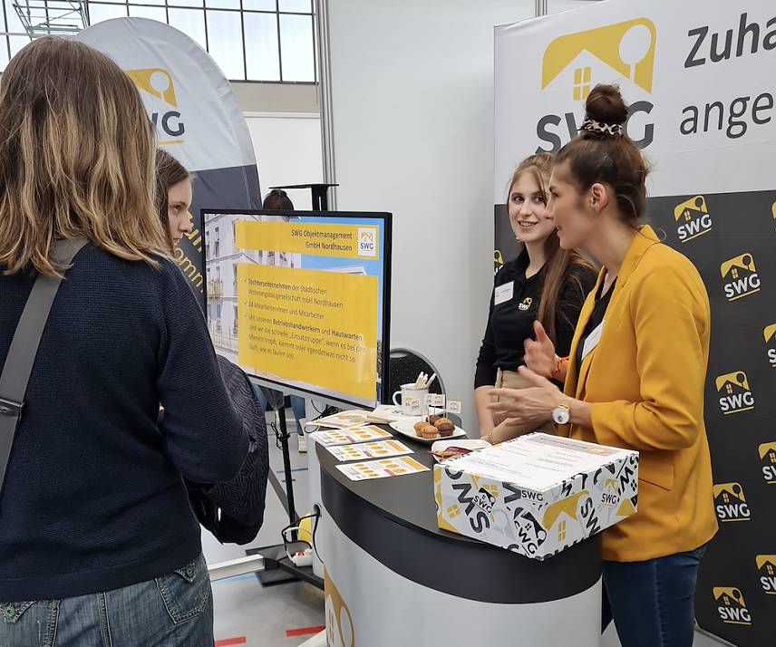 Bild:  Die St&auml;dtische Wohnungsbaugesellschaft (SWG) pr&auml;sentiert sich und ihre Ausbildungsberufe wieder beim Forum Berufsstart in der Nordh&auml;user Wiedigsburghalle. Sarah Krug (rechts) und Laura Gorges von der SWG im Gespr&auml;ch mit interessierten Sch&uuml;lerinnen.