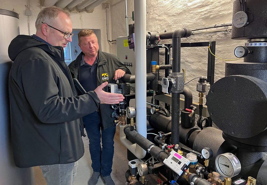 Bild: Norman Tennemann (links), Fachplaner der Firma HESA, im Gespr&auml;ch mit SWG-Projektleiter Steffen Peter, hier im Keller an der neuen Fernw&auml;rme&uuml;bergabestation.