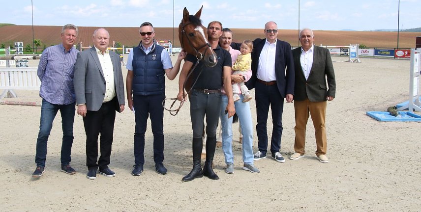 Bild: Der "Star" auf diesem Bild hei&szlig;t "Cocodello" und sprang beim Gro&szlig;en Preis von Immenrode auf den zweiten Platz. F&uuml;r die vierte Auflage des Turniers sorgen die Menschen, darunter v.l.: Ralph Mackerodt, Helmut Peter, Nils Neu, Michael Zwingmann, Julia Mackerodt-Zwingmann, Landrat Matthias Jendricke und Sportkoordinator Werner H&uuml;tcher
