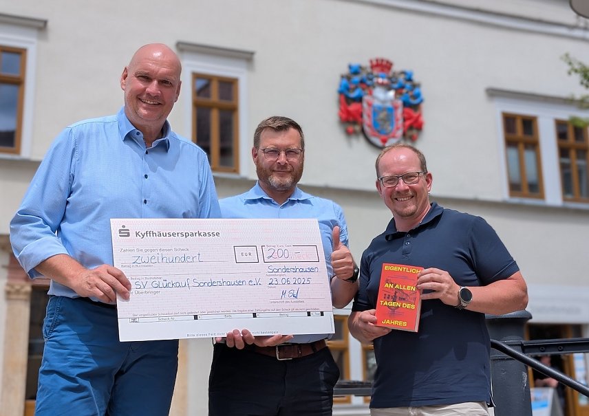 Bild:  B&uuml;rgermeister Steffen Grimm (links) und Gesch&auml;ftsf&uuml;hrer der Stadtmarketing GmbH, Marcus Strunck (rechts), &uuml;berreichten den Scheck an Daniel P&ouml;&szlig;el (Mitte), Vorstandsvorsitzender des SV Gl&uuml;ckauf Sondershausen.