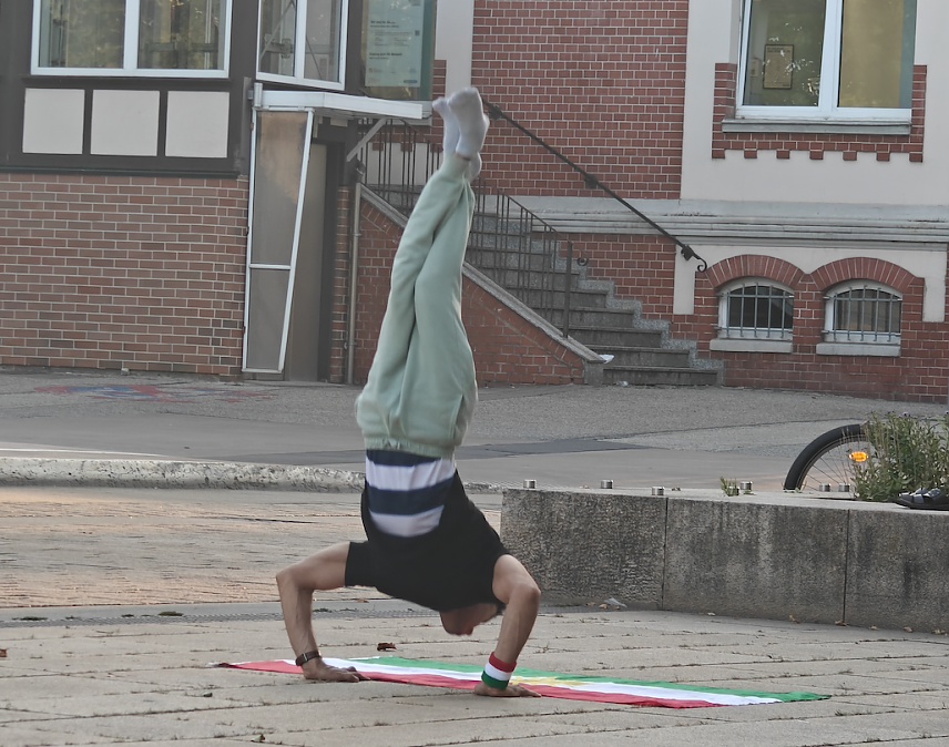 Bild: Sportlicher Flaggenhandstand auf dem Bahnhofsplatz