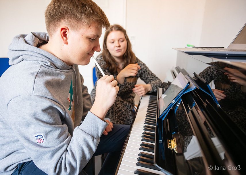 Bild: Ein junger Musiksch&uuml;ler sitzt an einem Klavier und &uuml;berlegt