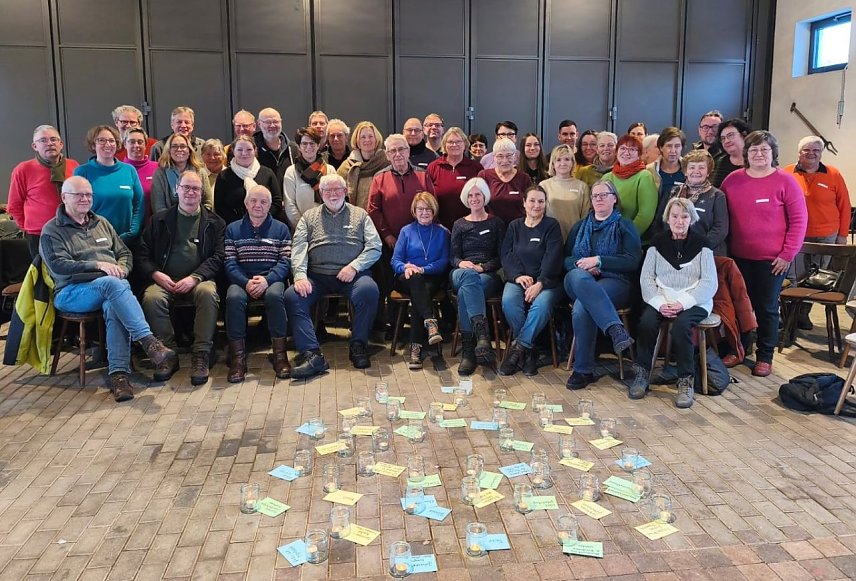 Bild: Eine Gruppe von Menschen vor auf dem Boden ausgebreiteten Klebezetteln