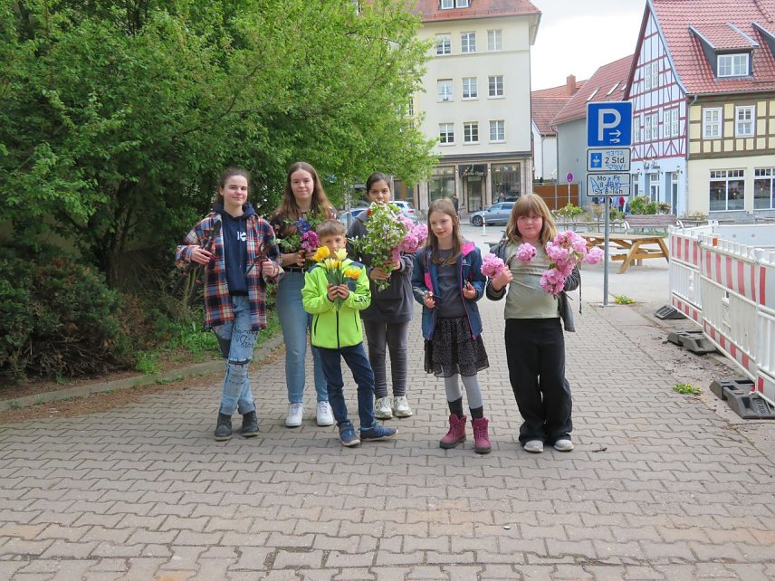 Bild: Kinder mit Blumen auf dem Kirchplatz