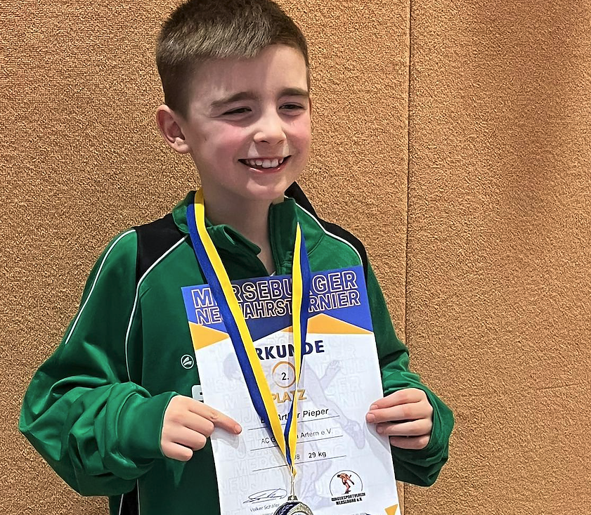 Bild: Ein Junge mit Urkunde und Medaille