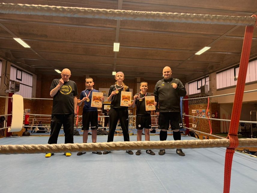 Bild: Zwei Boxtrainer und drei junge Sportler
