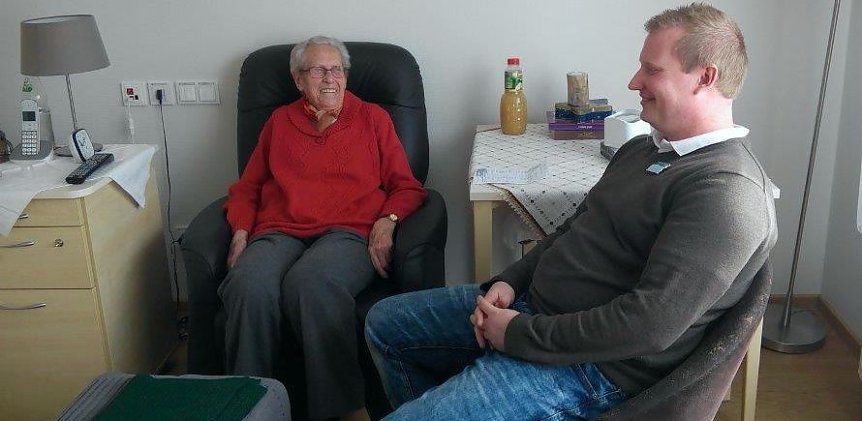 Bild: Milly J&auml;ger in ihrem Zimmer im Gespr&auml;ch mit Pflegedienstleiter Robert Hippmann.