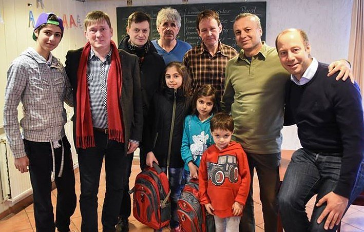 Arne Lietz (r.), Norbert Born (2. v. l.) und Mike K&uuml;nzel (3. v. l.) in der Unterkunft f&uuml;r Fl&uuml;chtlinge in Eisleben. Born und Lietz schenkten zwei M&auml;dchen, die ab Montag in Eisleben zur Schule gehen werden, je einen gef&uuml;llten Schulranzen. (Foto: Daniel Acker)