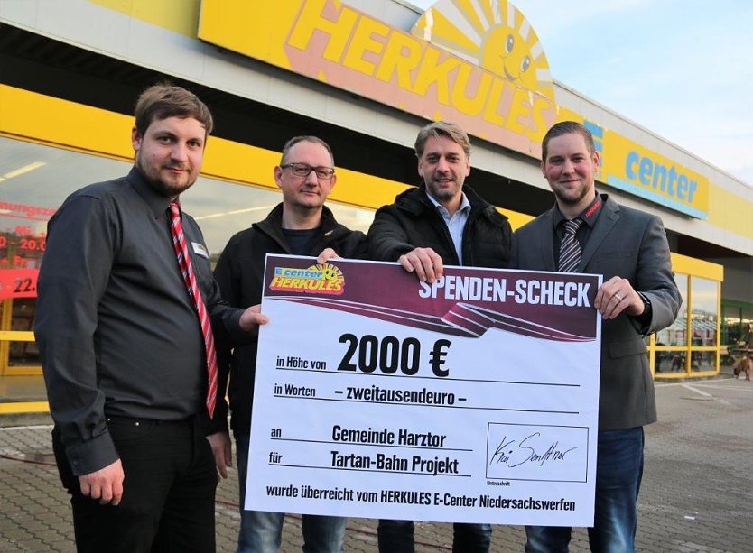 Christian Setzer, stellvertretender Marktleiter, Harztorlauf-Chef Dirk Wackerhagen, B&uuml;rgermeister Stephan Klante und Marktleiter Kai Senftner(v.l.n.r.) mit Spendenscheck vor dem Herkulesmarkt in Niedersachswerfen. (Foto: Gemeinde Harztor)