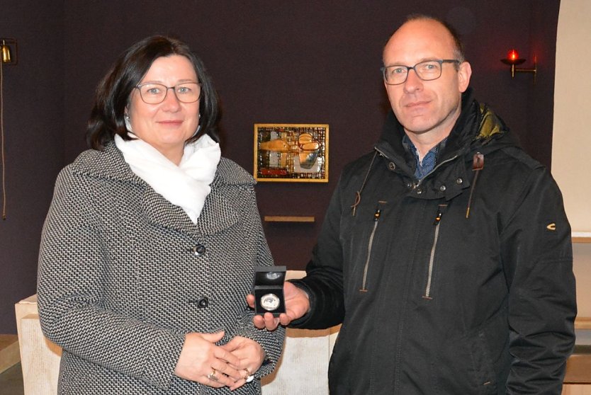 Annette Klingebiel bei der &Uuml;bergabe des Talers an Pfarrer Roland Genau. (Foto: Kreissparkasse Eichsfeld)