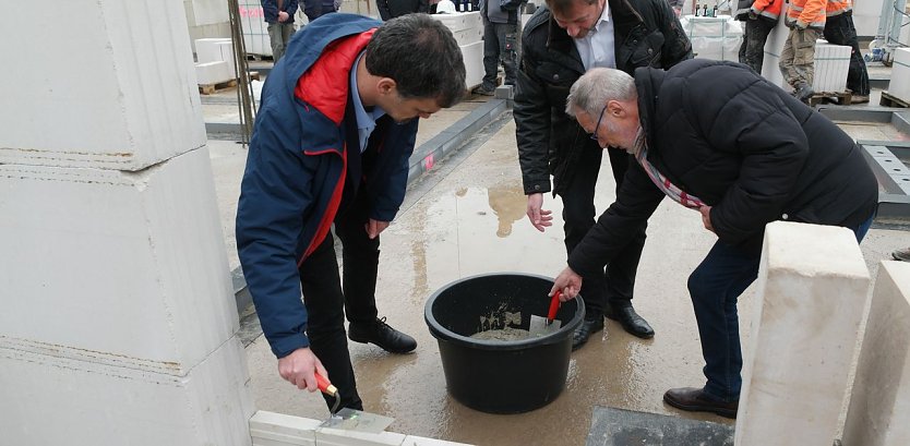 Gemeinsam mit OB Buchmann und DRK-Pr&auml;sident Weith wird die Schatulle zugemauert. (Foto: nnz)