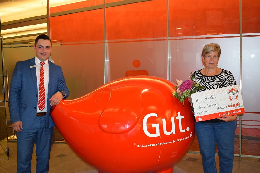 Kundenberater Maximilian Heine (Filiale Kornmarkt) &uuml;berreicht der gl&uuml;cklichen Gewinnerin einen symbolischen Scheck (Foto: Kreissparkasse Nordhausen)